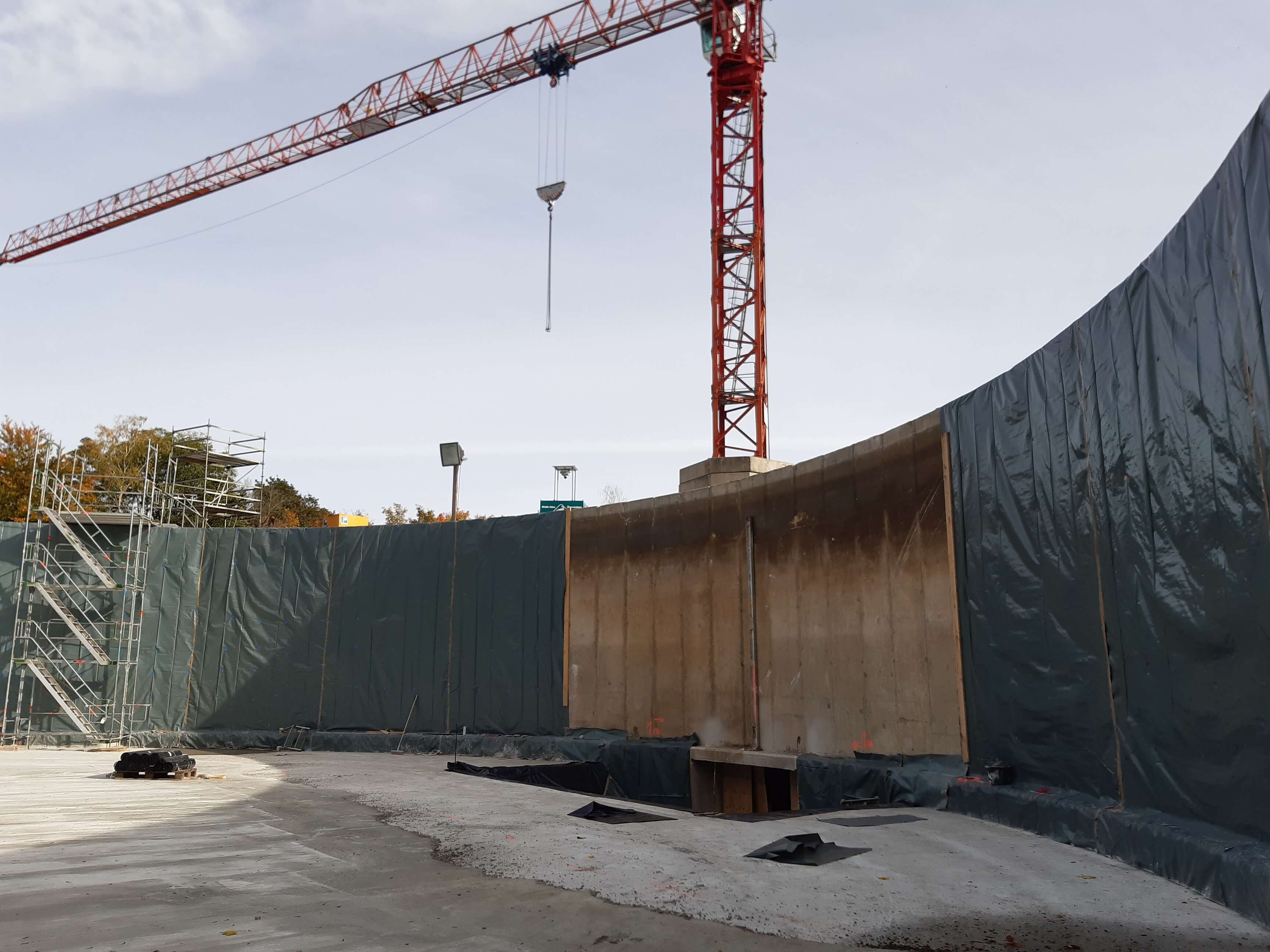Eine Folie wird als Trennschicht zwischen neuer Betonwand und der alten Wasserkammer aufgebracht.