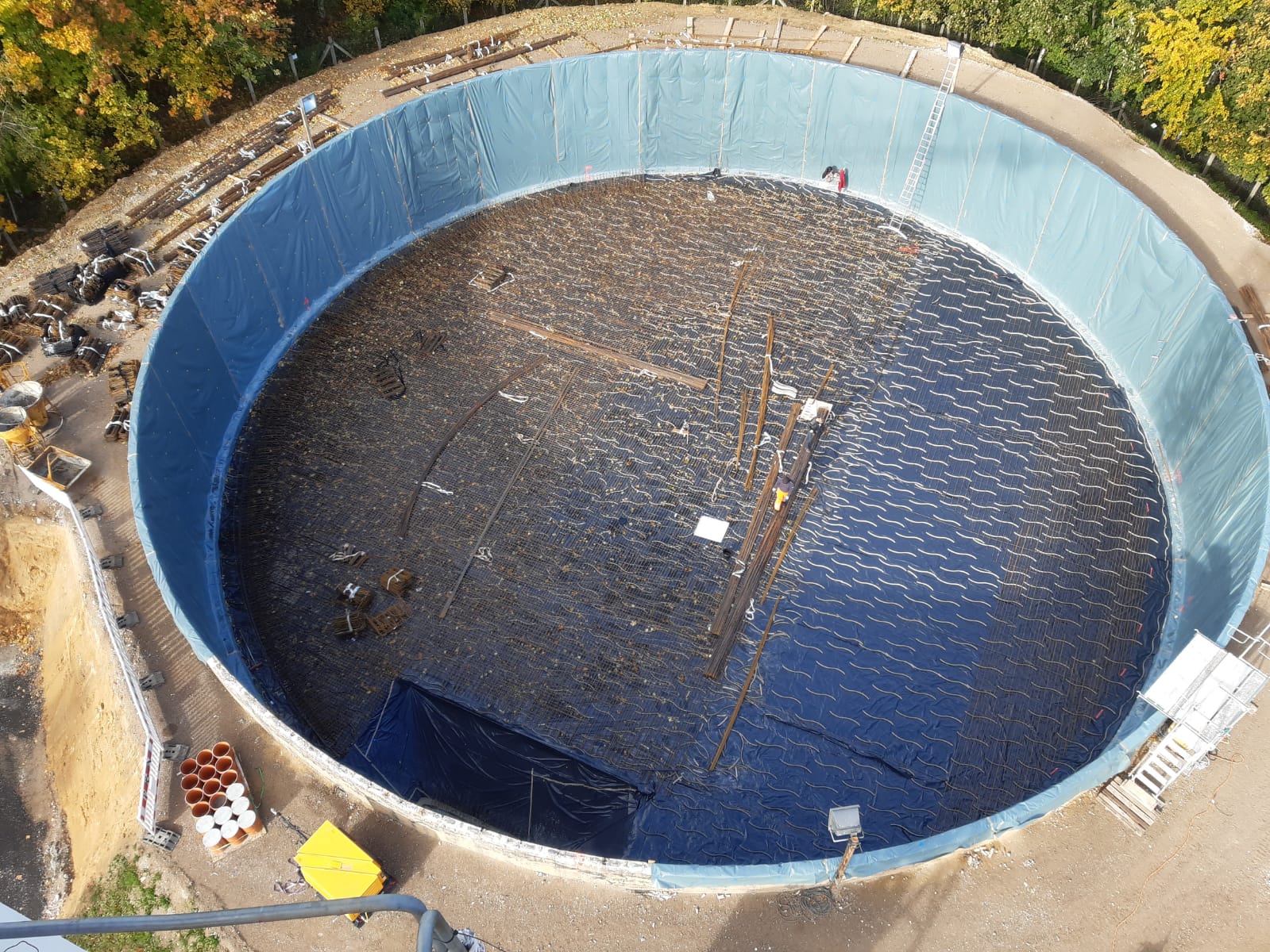 Eine Folie wird als Trennschicht zwischen neuer Betonwand und der alten Wasserkammer aufgebracht.